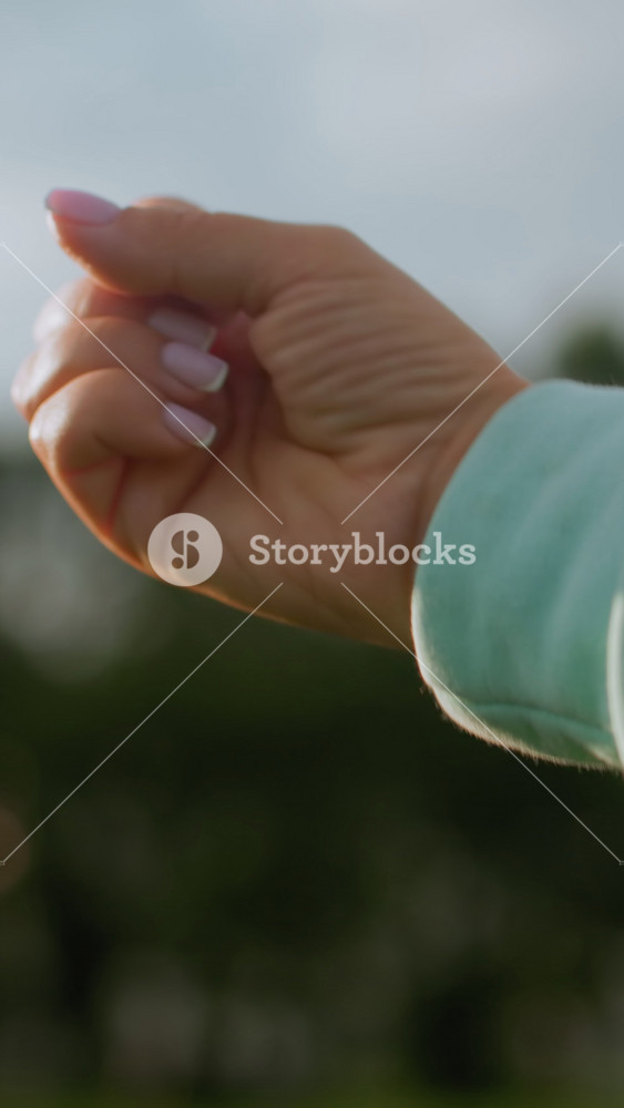 Outdoor park gift gesture, Caucasian woman extending treat outdoors, Closeup of woman giving treat in park setting, An intimate moment as