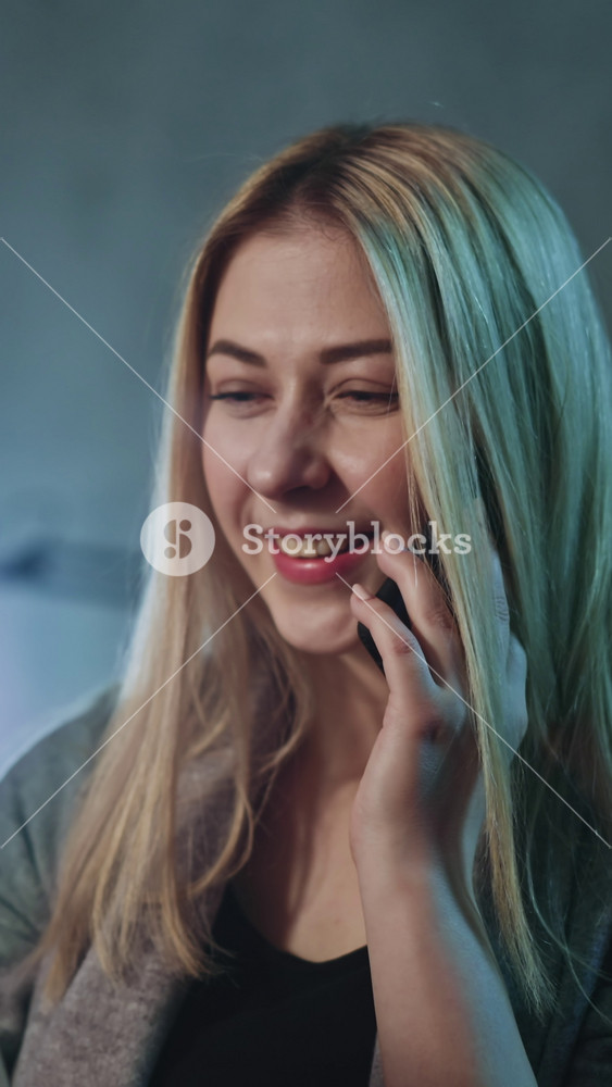 Positive woman tells about friend recuperation at call holding ultrasonography photos on blurred background in semi-dark room closeup slow