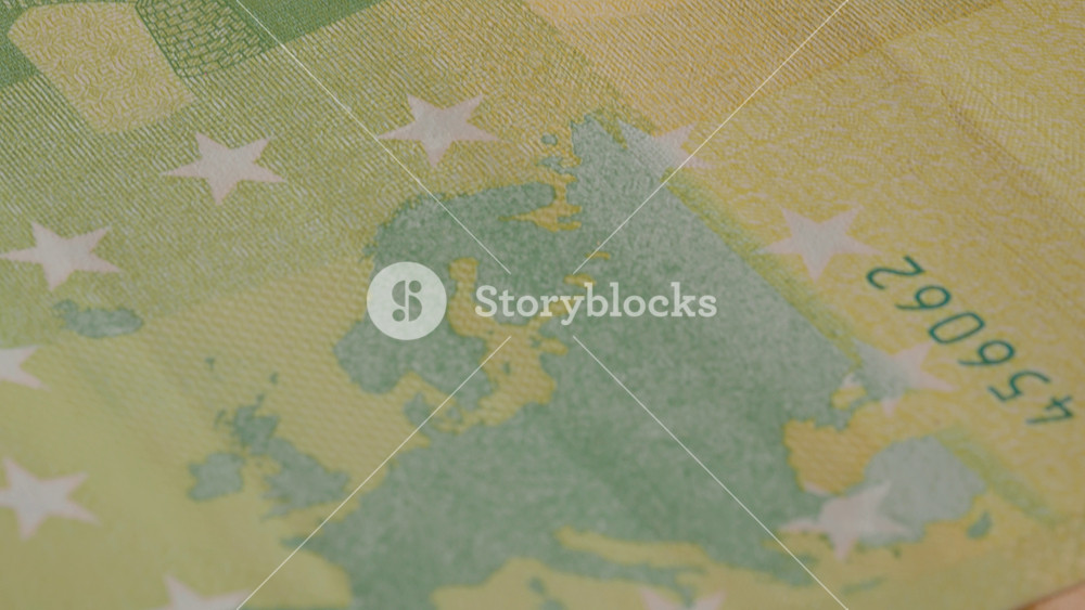 Close-up view of a euro banknote highlighting its unique design, including regions and symbols that represent the European Union and its diverse culture.