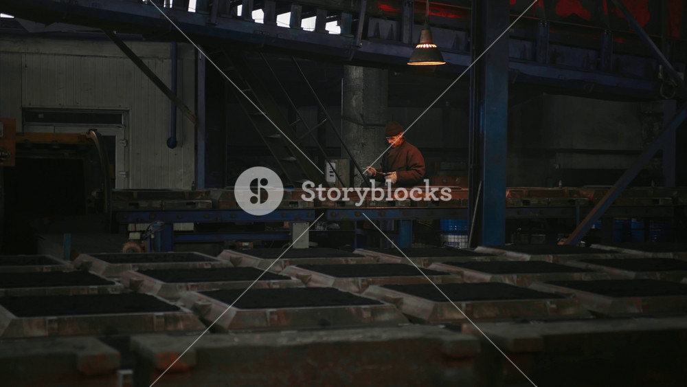 Chisinau, Republic of Moldova, - October 2024: Metal production process in a metallurgical factory large view. Man worker checking metal casts.