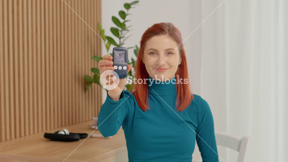 A woman smiles as she displays her glucometer reading of 87 mg dL. She shares her journey in managing blood sugar levels and living with diabetes.