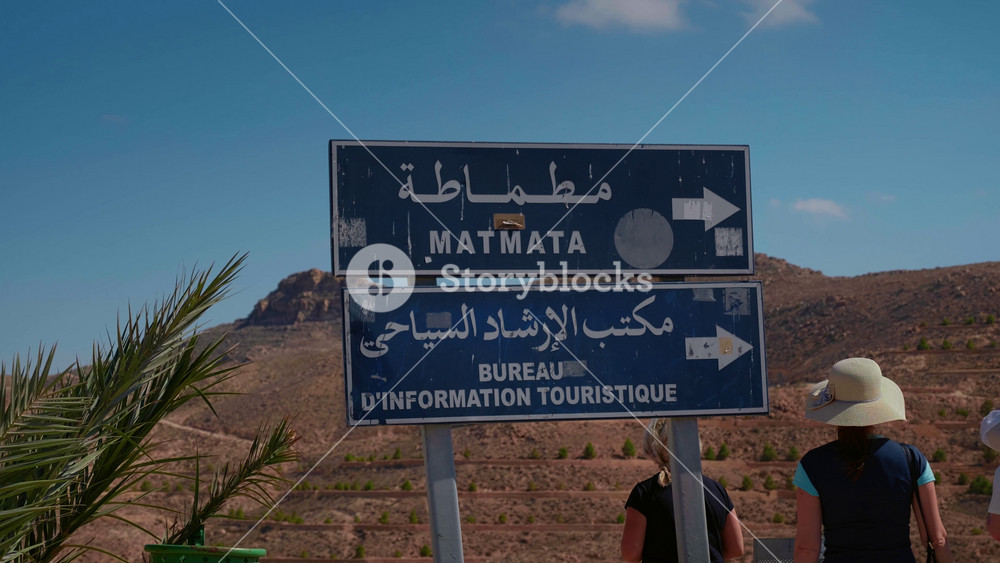 Matmata, Tunisia - 02 sept 2024: Street sign showing the name of the city Matmata in English and native language. Easy acces to the city with direction simbols.