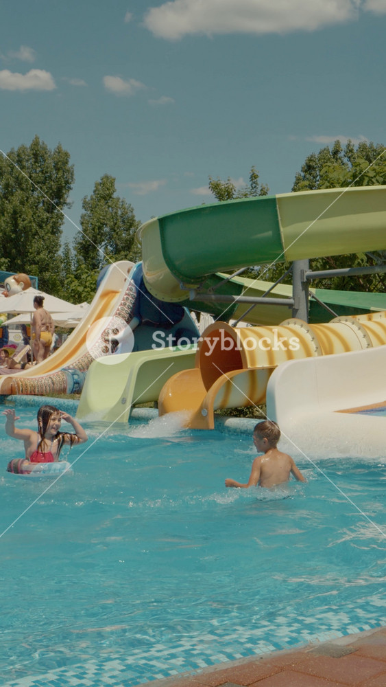 Chisinau, Republic of Moldova, - 20 August 2024: Vertical Screen Colorful aquapark and children's pool with playground for children during summer vacation. Summer attraction.