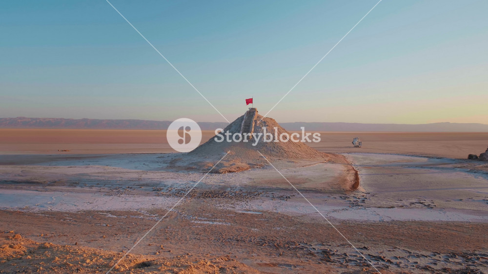 Red flag on the top point of deserted tunisian lake Chott el Djerid. Very arid conditions in Africa almost dried lake.