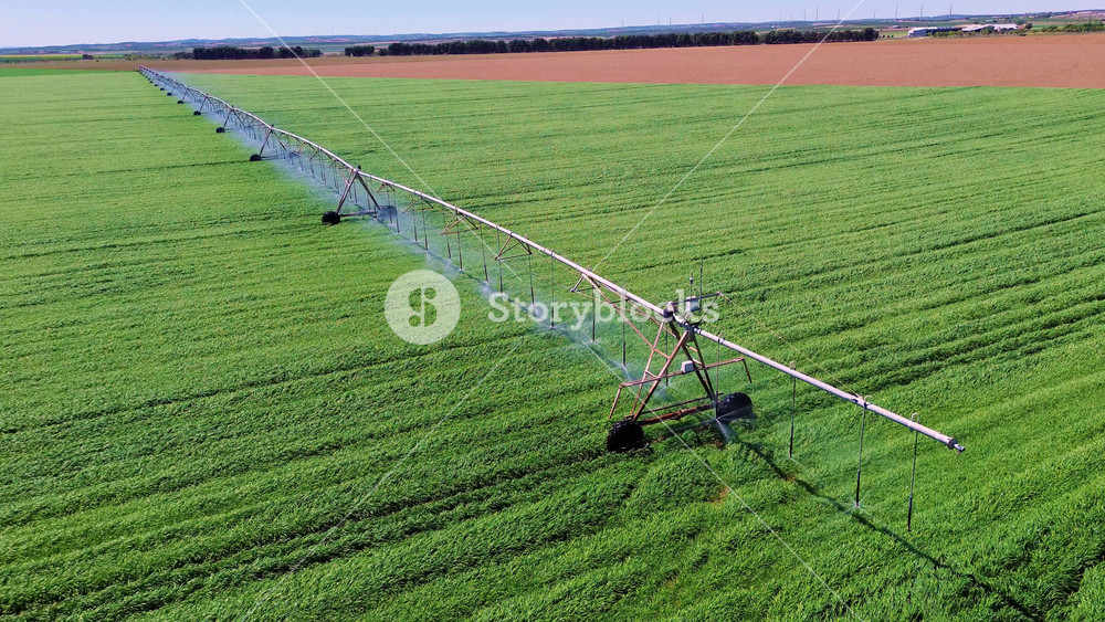 Aerial close view of center pivot irrigation system watering green field in Castilla La Mancha, rotating sprinklers and sustainable agriculture concept