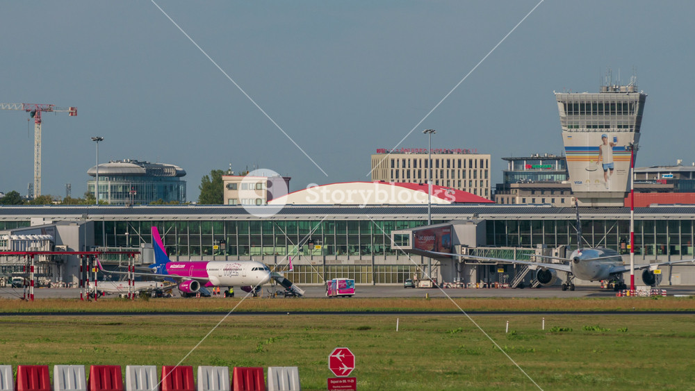 Warsaw, Poland - 03.07.2024: time-lapse Chopin airport airfield on summer sunny day. Air traffic operation on the ground, passengers loading, loading of baggage, aircrafts before flight, airport life