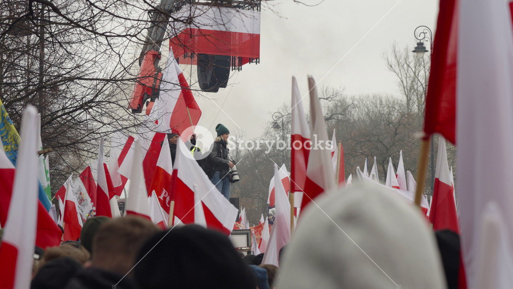 Warsaw, Poland - March 6, 2024: group of people carrying red and white flags on the street, farmers protest, demonstration of protesting agricultural workers, photojournalist takes photo
