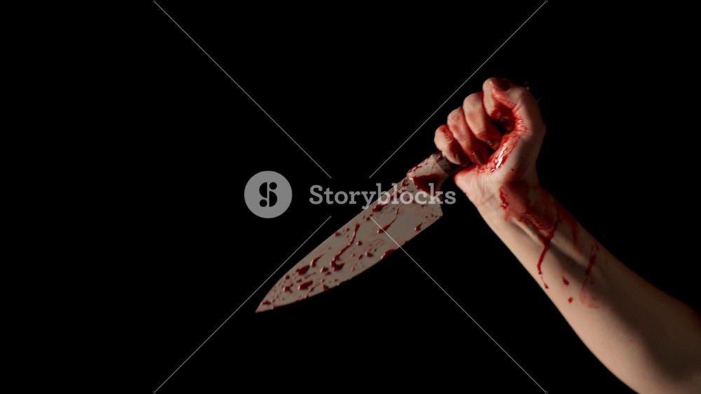 Human hand with bloody knife shot on black background. Female, woman's hand in blood holds knife. Concept of violence, murder with kitchen knife