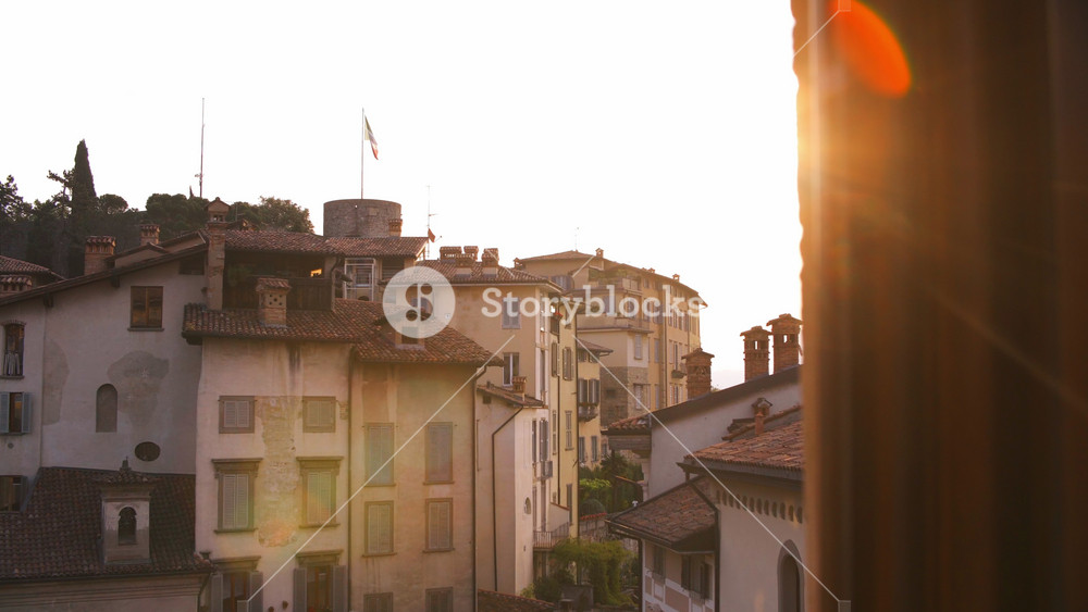 Early morning sunrise in Citta Alta ancient upper town of beautiful Bergamo city in alpine Lombardy region of northern Italy. Red tiled roofs and windows with wooden shutters of old buildings