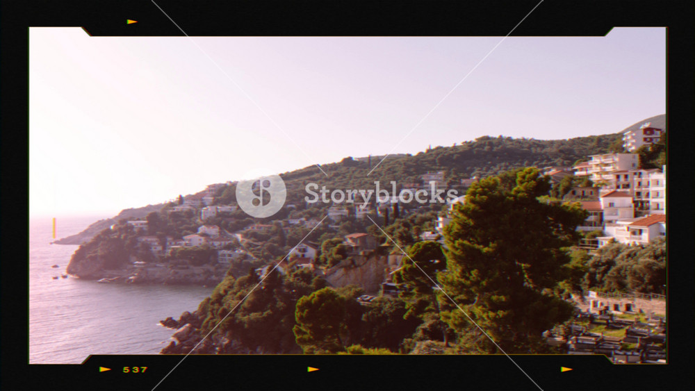 Retro movie camera with old house of city Ulcinj and Adriatic sea in Montenegro. Summer landscape with mountain and clear blue sky