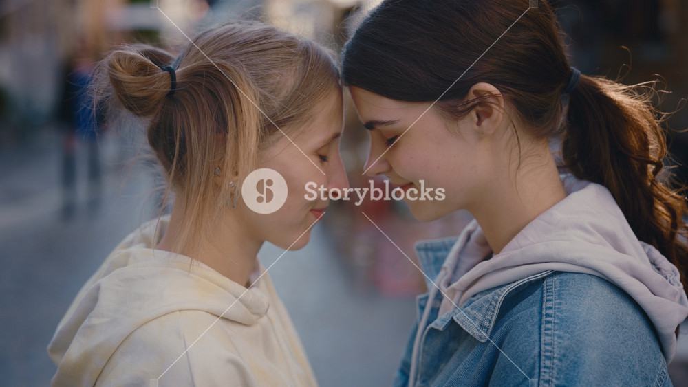 Two pretty women smiling and rubbing noses close-up. Beautiful lesbian couple enjoying together. Close up. Romantic date, love, tender