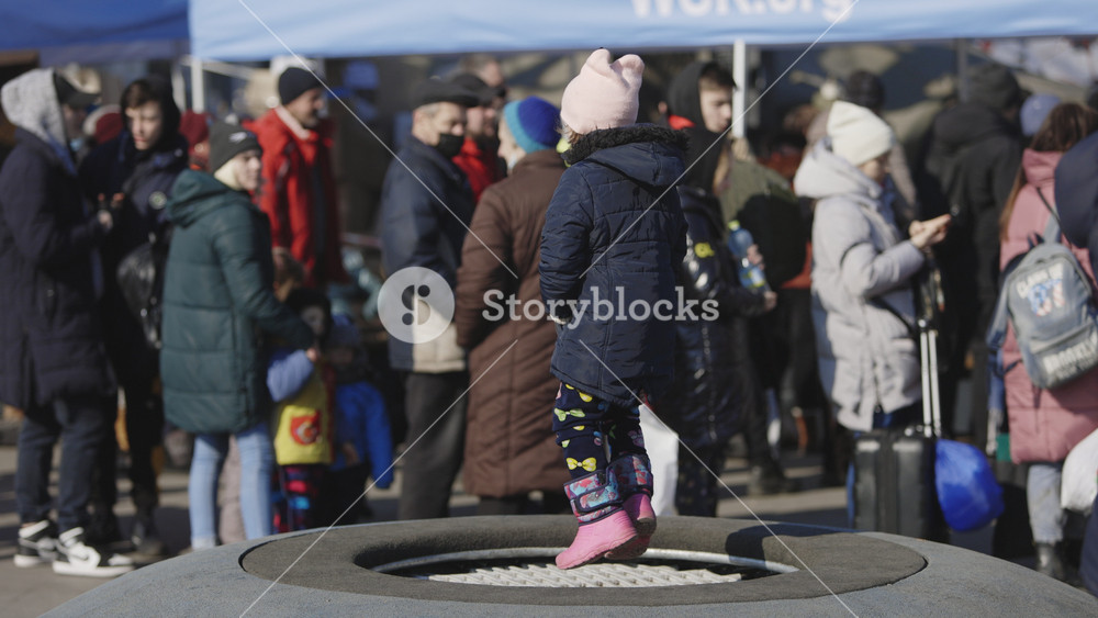 Lviv, Ukraine - March 15, 2022: Evacuees from eastern Ukraine near the railway station in western Ukrainian city of Lviv. Little girl