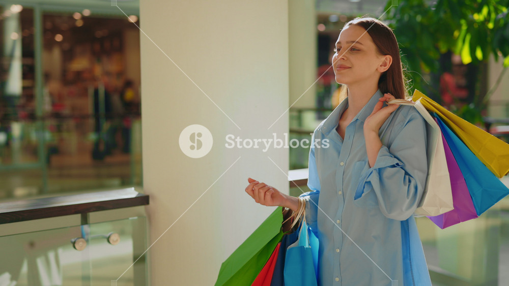 Smiled Young Female Customer Feeling Happy After Shopping Walking in the Mall. Side View of the Buyer Come Back Home with Many Colorful