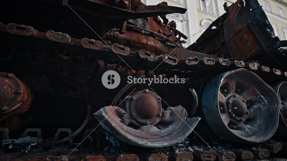 Caterpillar and wheels track of burned-out Russian tank. Close up. soldier hand touches a tank track. Military battle army war concept