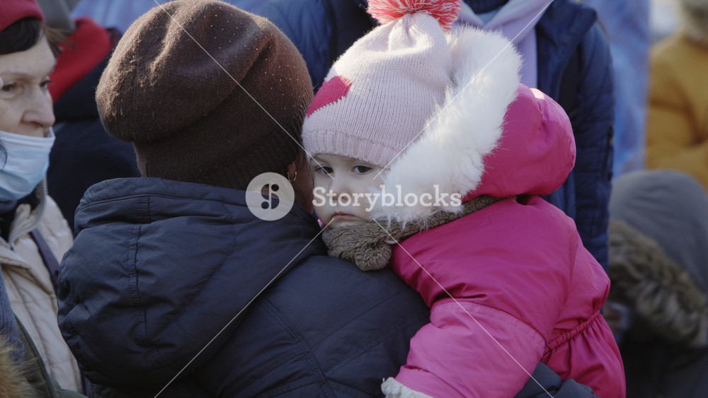Lviv, Ukraine - March 15, 2022: Mother and daughter. Refugees from Ukraine waiting for the train at the railway station. Portrait view. War