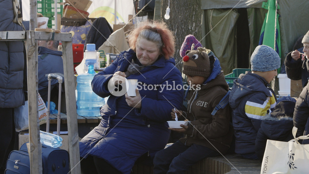 Lviv, Ukraine - March 15, 2022: Refugees at the railway station of Lviv waiting for the train. Little child sitting with his mother and