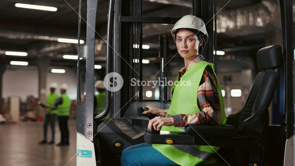 Portrait of a Beautiful Warehouse Woman Sitting in a Forklift Truck, Smiling at the Camera. Positive Driver Engaged in Work in a Industrial
