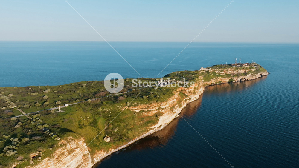 Cape Kaliakra peninsula aerial wide view Black Sea Bulgaria green clifftop lighthouse ruins slow motion travel nature coastline landmark geology dramatic horizon