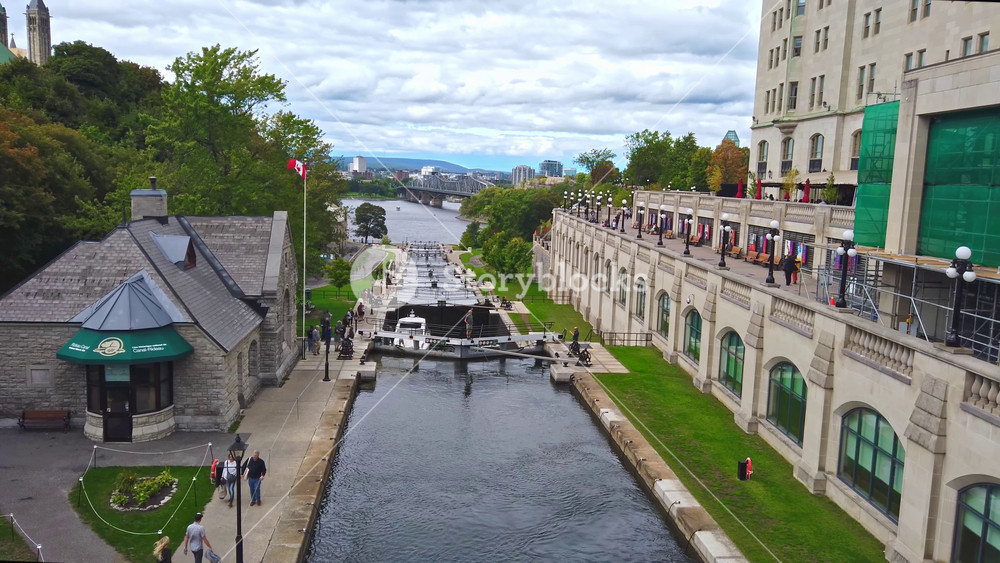 OTTAWA, CANADA - SEPTEMBER 21, 2019: Timelapse of walking people near Bytown museum and closing bridges on Rideau Waterway in daylight. Top view