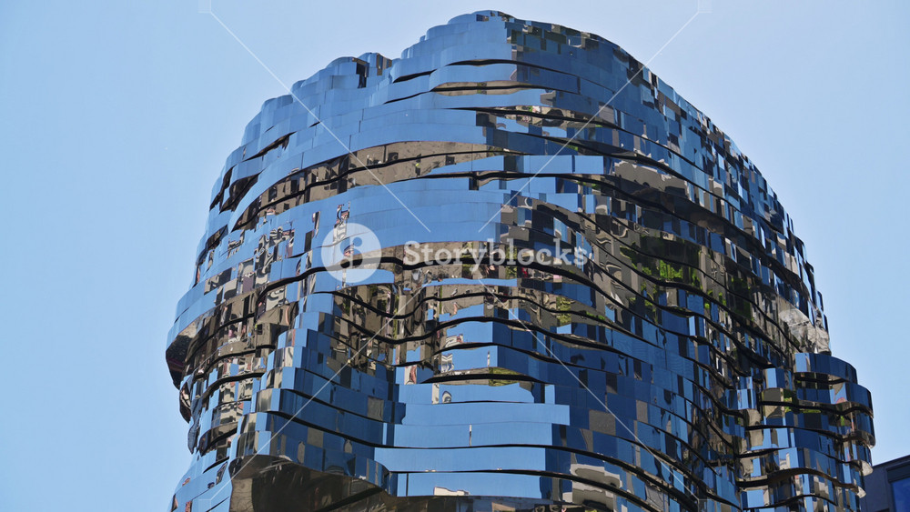 Prague, Czech Republic - July 19, 2026: Close-up of the Franz Kafka Head sculpture against a clear blue sky, its mirrored layers forming the face