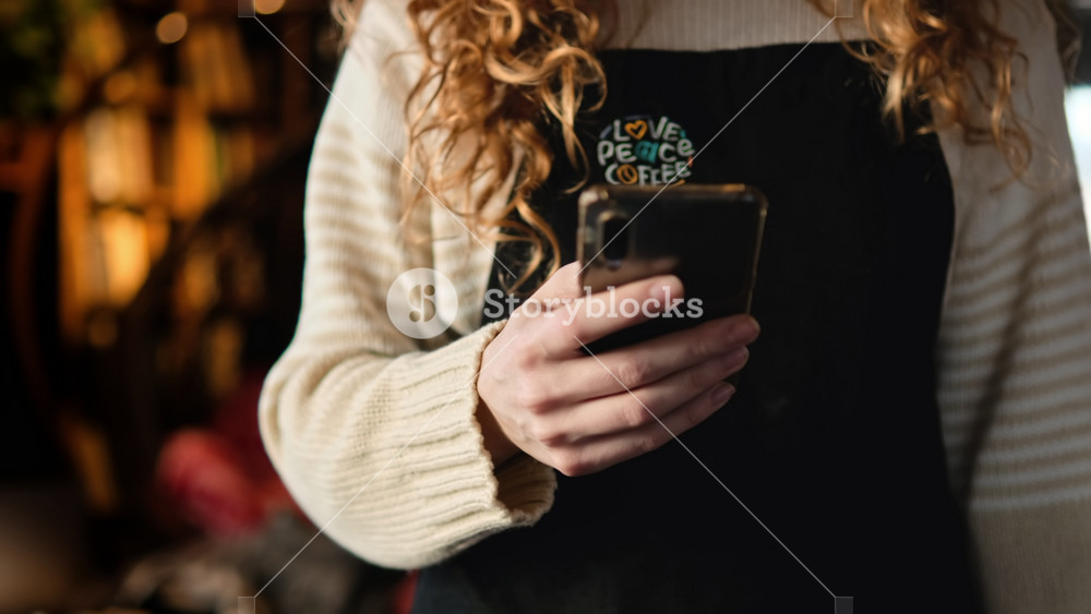 CHISINAU, MOLDOVA - FEBRUARY, 2022: Woman showing smartphone with International Vaccination Certificate COVID-19 to the barista in a cafe. Booster dose. Scanning the QR code.