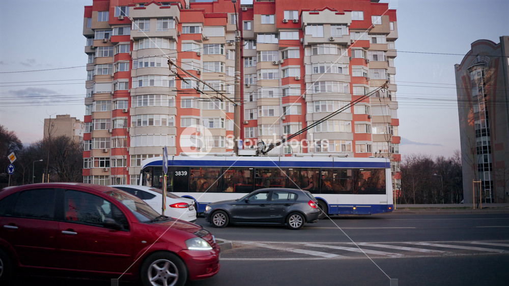Chisinau, Moldova - March 18, 2026: Public trolleybus and cars passing in front of modern residential apartment buildings in Chisinau