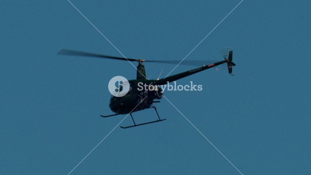 Helicopter flying solo through a clear blue sky, aircraft showcasing aviation and aerial transport, Antibes, France