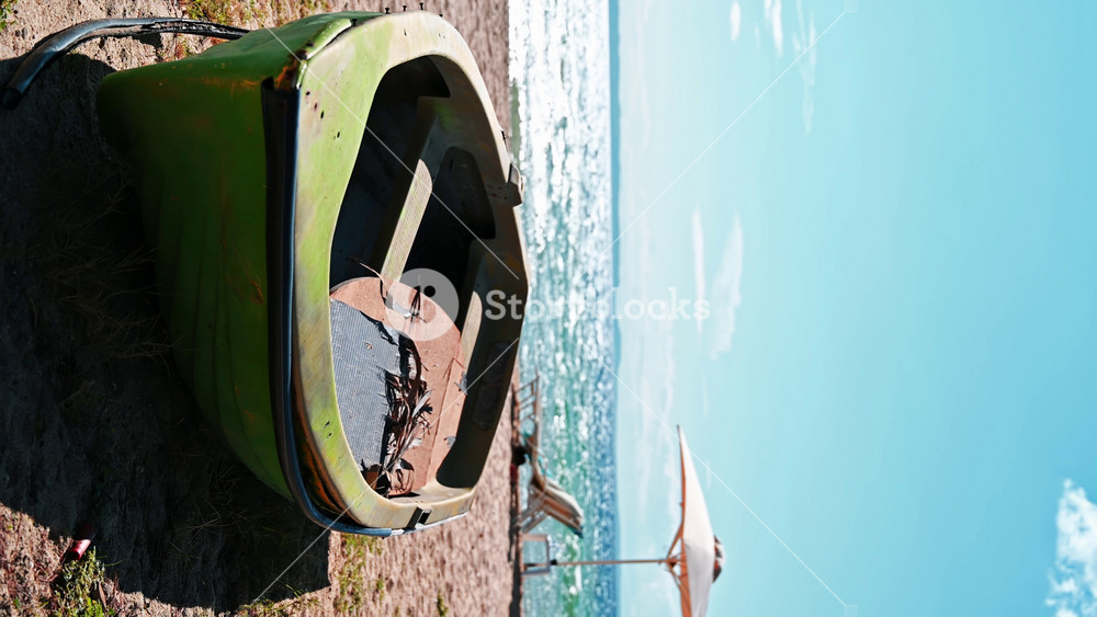 Beached boat made of green colored metal, umbrellas, sunbeds and Aegean sea on the background in Nikiti, Greece. Vertical shooting
