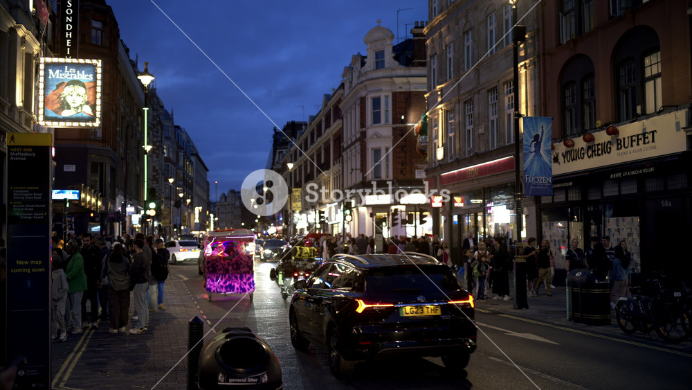 LONDON, UNITED KINGDOM - SEPTEMBER 12, 2023: Street scape of the downtown at evening. Street with walking people, movings cars, cafes and classic buildings, illumination