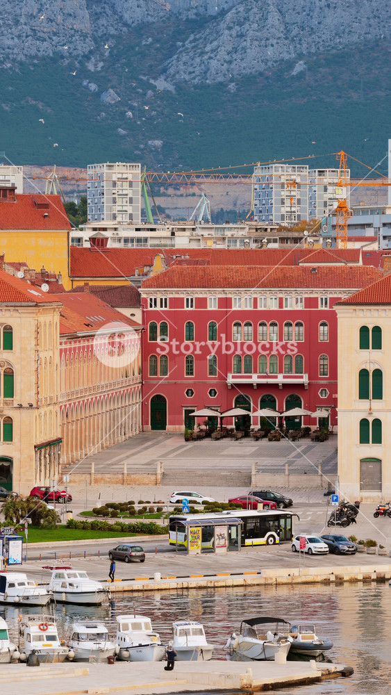 Split, Croatia - November 19, 2025: Aerial drone view of the Riva promenade with boats in the marina and the colorful facade of Prokurative behind it. Vertical