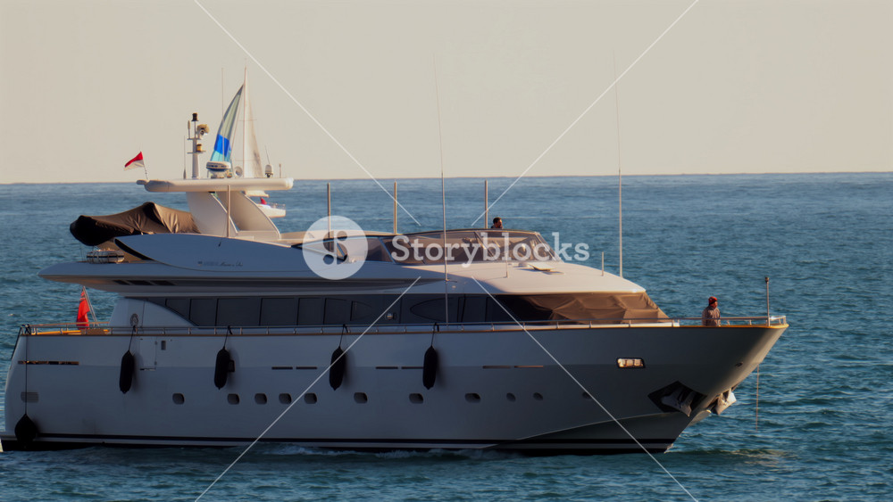 Nice, France - February 10, 2025: A boat with the flag of Monaco moving on the sea with small sailboats on the background