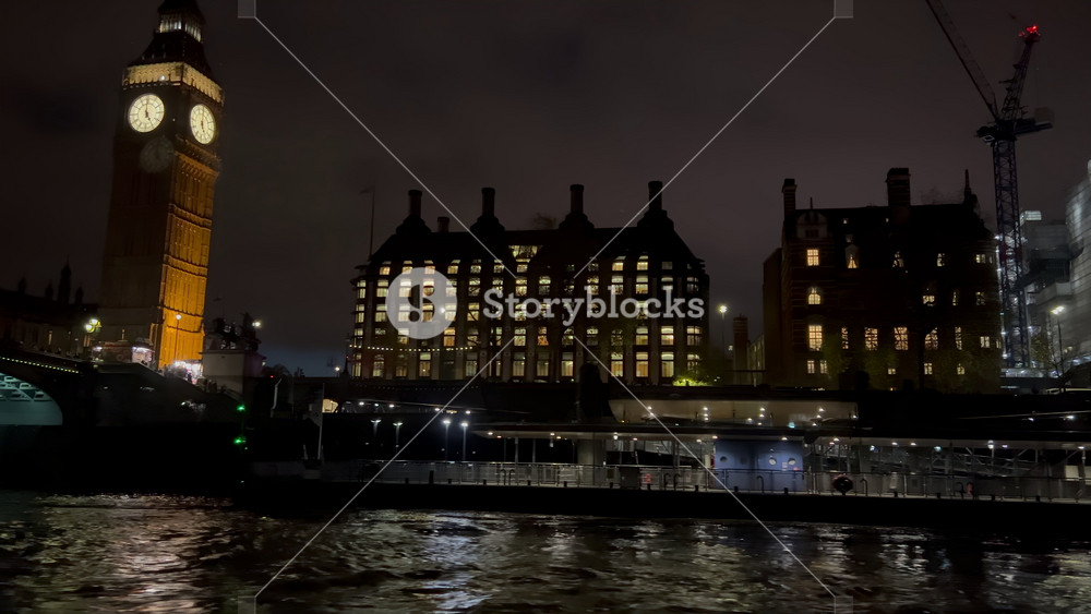 View from a moving boat of the Big Ben and the buildings alongside the Thames River in the evening in London, England