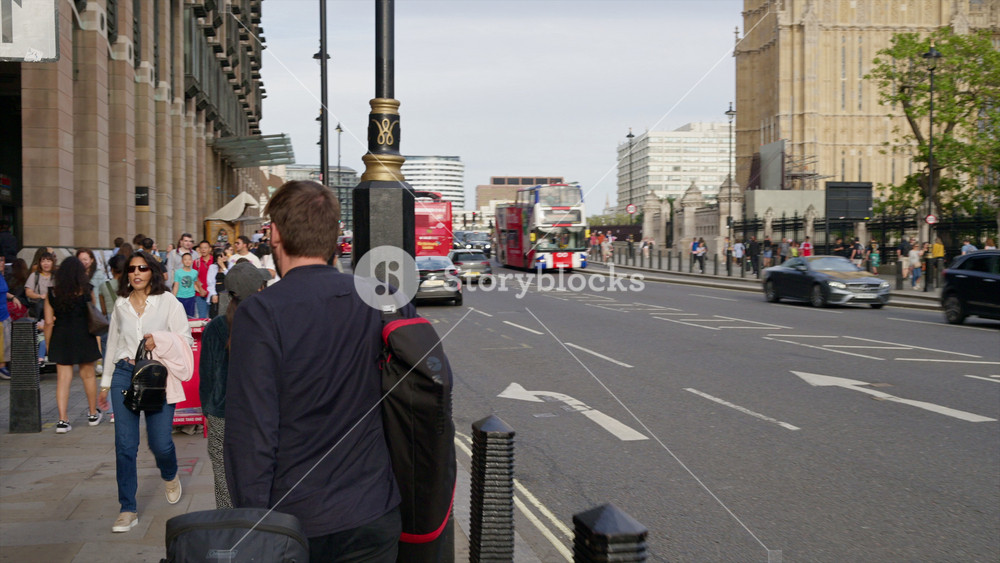 LONDON, UNITED KINGDOM - AUGUST 11, 2023: Street scape of city downtown with multiple walking people and moving cars near the Westminster Palace