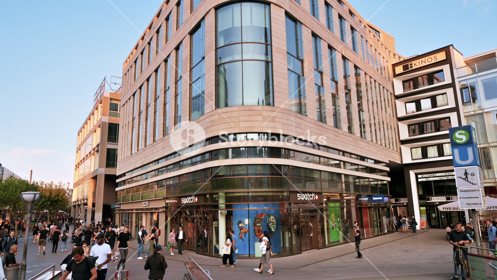FRANKFURT, GERMANY - SEPTEMBER 11, 2022: Street view of the city downtown at sunset. Square with underground station, multiple walking people and modern buildings