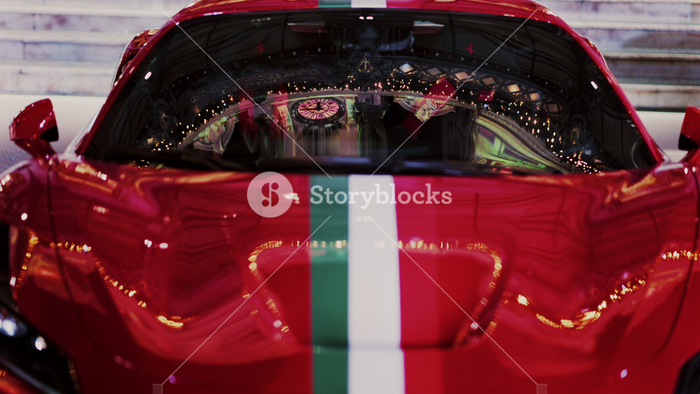 Close up of a red car with the Italian flag on it in the courtyard of the Monte Carlo Casino in the evening in Monaco