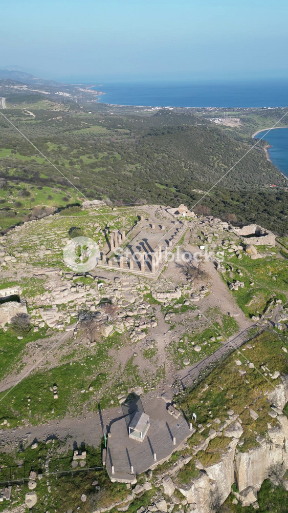 Aerial view of the ancient Temple of Athena ruins on the acropolis of Assos (Behramkale) over the Aegean Sea in Canakkale, Turkey. 4K