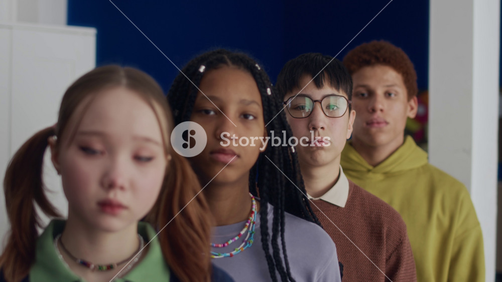 Close up portrait of diverse teenagers including Asian and African American girls, Asian and biracial boys looking at camera with dramatic gaze