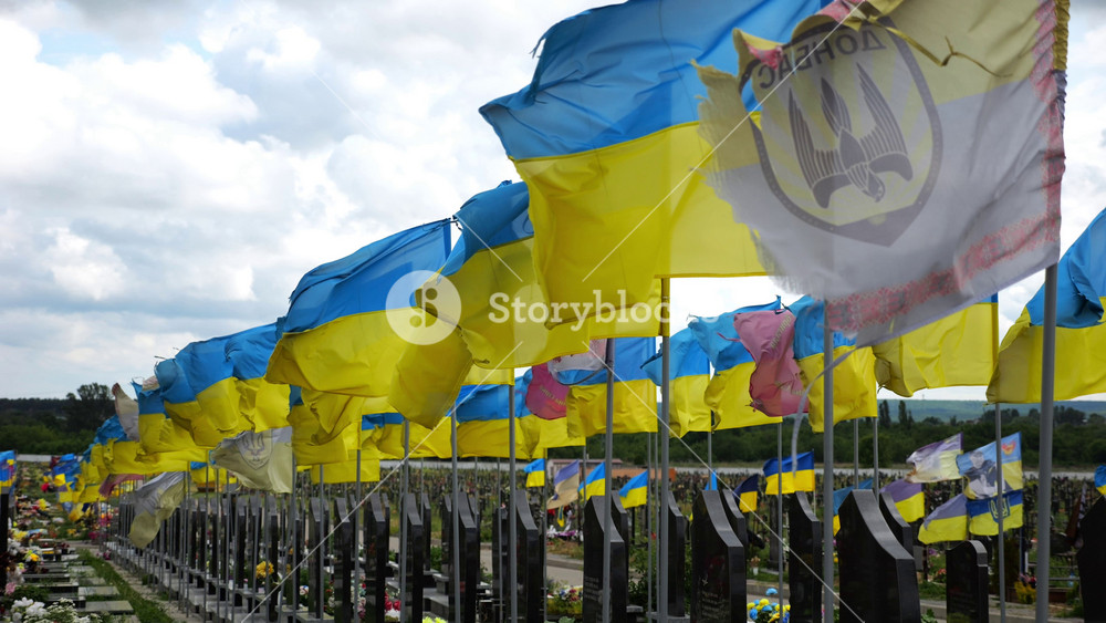 View on blue-yellow flags at countless graves of ukrainian soldiers alley of glory in Kharkiv. This site commemorates heroes and maintains