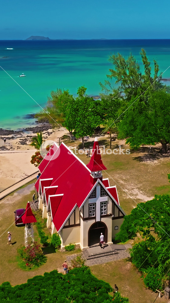 Cap Malheureux, red church Notre Dame de Auxiliatrice, rural church with red roof in Cap Malheureux tropical village at north on Mauritius