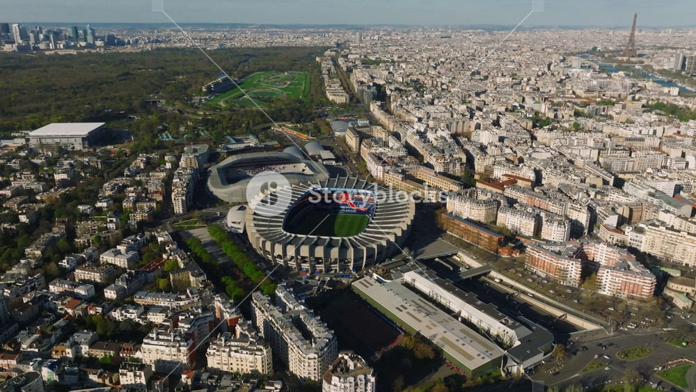 Bird's eye view of a modern sports stadium in Paris, France. A drone flies over a sports facility. Aerial view of the city center and rooftops