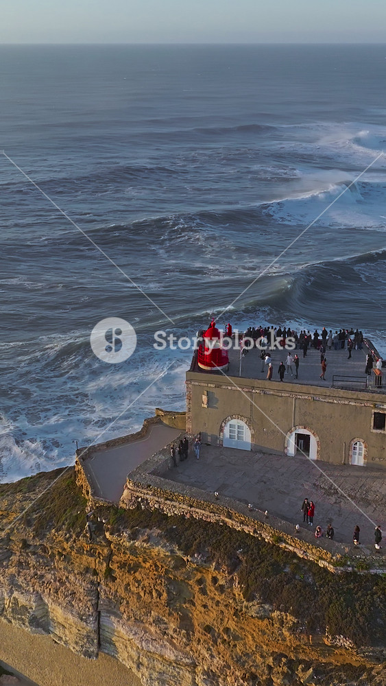Aerial view of Nazare Lighthouse. The world's biggest waves crashing against the rocks of the stunning lighthouse. Portugal