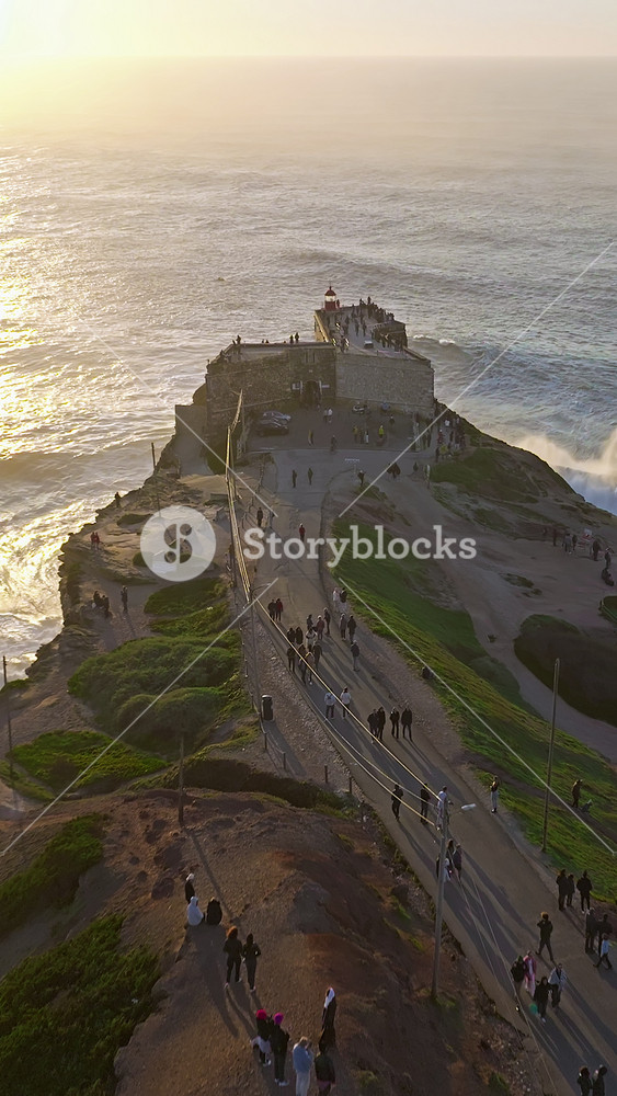Aerial view of Nazare Lighthouse. The world's biggest waves crashing against the rocks of the stunning lighthouse. Portugal
