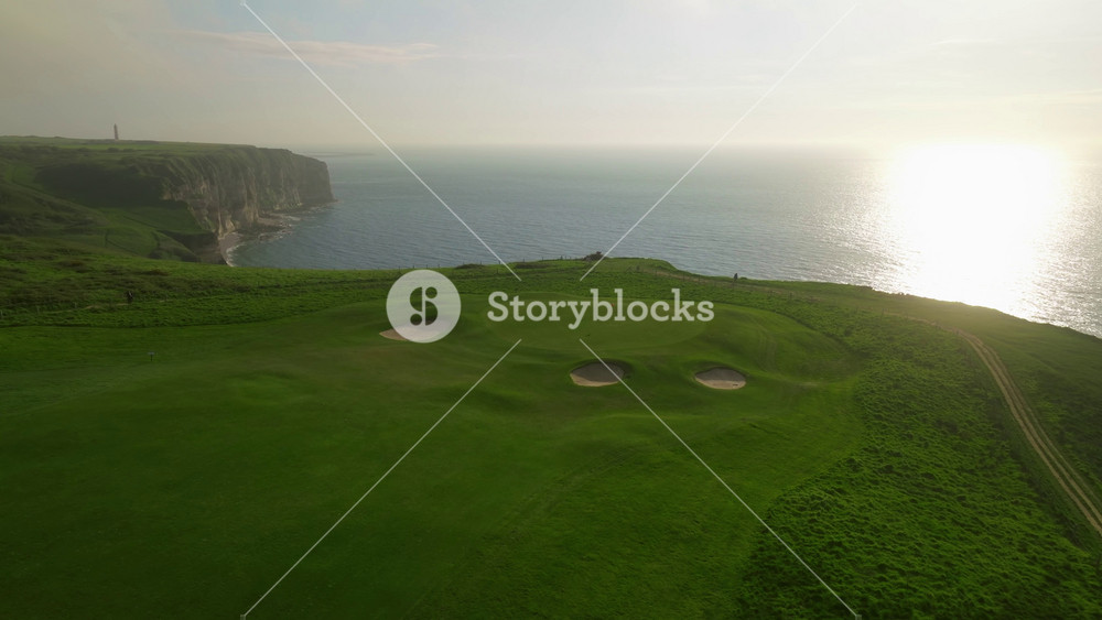 Aerial view of Etretat France coastal golf course green landscape set on cliffs along the Etretat shoreline. A sport for wealthy seniors who walk the hills by the ocean. Green golf courses