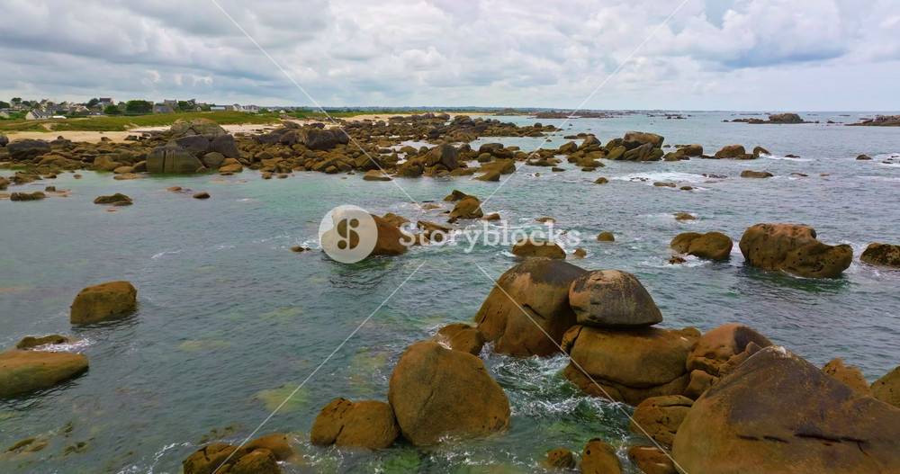 Aerial view of amazing rocky coast of the Atlantic ocean in France at sunset. Establishing shot of Bretagne. Drone flying above rocks