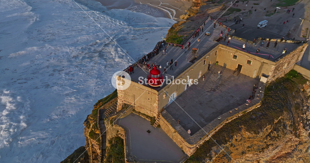 Aerial view of Nazare Lighthouse. The world's biggest waves crashing against the rocks of the stunning lighthouse. Portugal