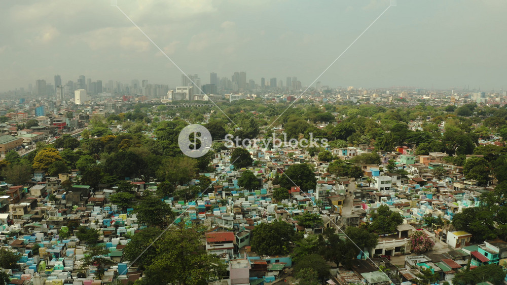Aerial view of panorama of Manila North Cemetery with skyscrapers and business centers in a big city. Travel vacation concept