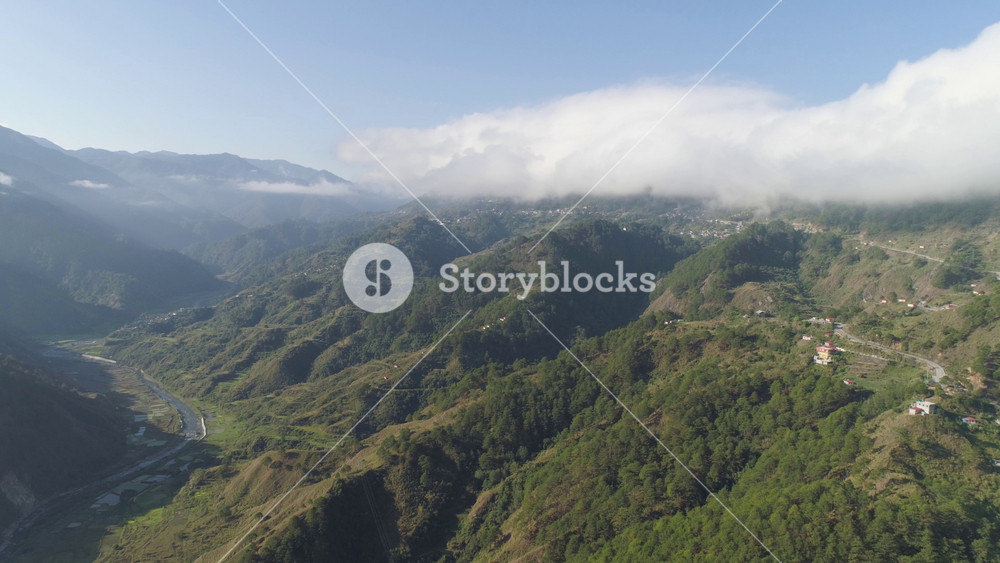 Aerial view mountains covered forest, trees in clouds and fog. Cordillera region. Luzon, Philippines. Slopes of mountains with evergreen