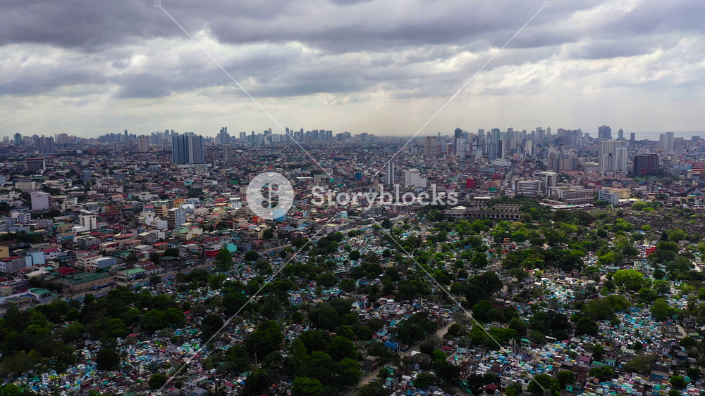 Manila North Cemetery on the background of skyscrapers and modern buildings, aerial drone. Travel vacation concept