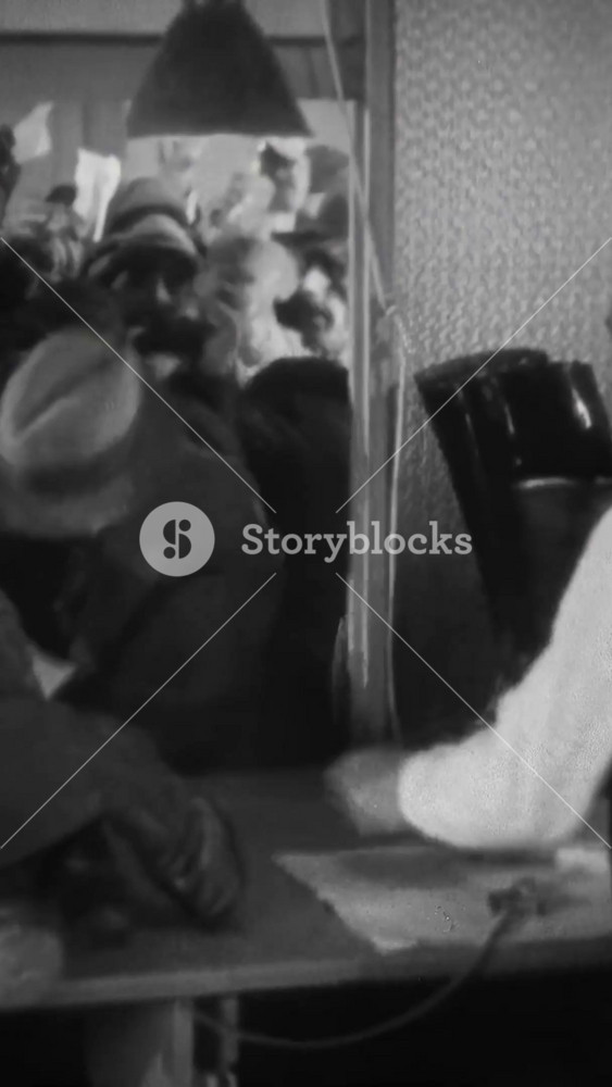 US - 1928 - in this silent drama, crowds of extras are picking up rifles, military hats, and boots for a film set, all rushing to get their items.