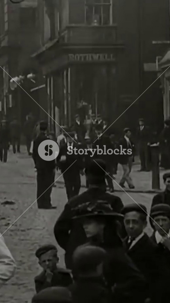 1902 - Street scenes shot in an English city show adults and children looking at the camera, and horse-drawn carriages being driven by.